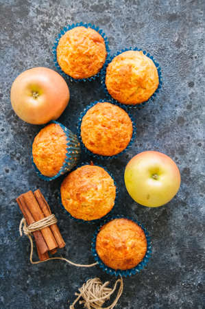Homemade apple cheese muffins on a wire rack. Blue stone background. Seasonal baking.の写真素材
