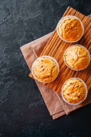 Homemade muffins with bacon and cheese on a black slate background. Healthy snack or breakfast meal.の写真素材
