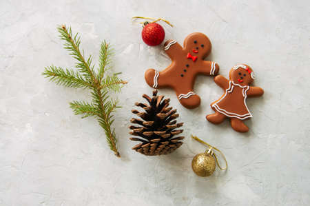 Christmas background. Gingerbread man and girl cookies, fir tree, cone, balls on a white stone background. Top view.の写真素材