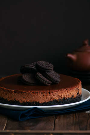 Chocolate cheesecake with cookies on a white plate.の写真素材