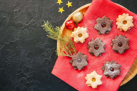 Plate of chocolate and vanilla linzer star cookies with raspberry and orange jam. Festive Christmas dessert.の写真素材