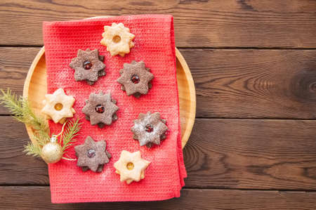 Plate of chocolate and vanilla linzer star cookies with raspberry and orange jam. Festive Christmas dessert.の写真素材