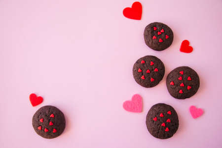 Chocolate cookies with hearts sugar on a pink background. Saint Valentie's Day concept.の写真素材