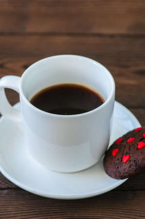A cup of black coffee and chocolate cookies on a wooden backdrop. Valentine's Day background. Copy space.の写真素材