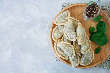 Fried savory pasties - hand pies with spinach on a white background. Top view and copy space.の写真素材