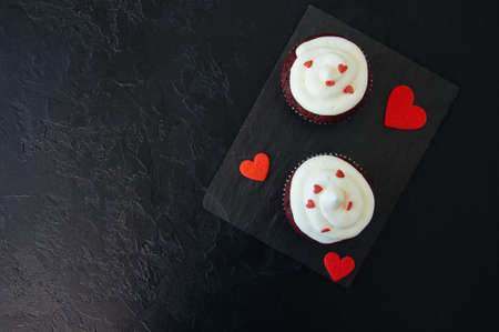 Red velvet cupcakes with cream cheese frosting on a white plateの写真素材