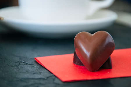 Heart shaped dark and milk chocolates on a black background.の写真素材