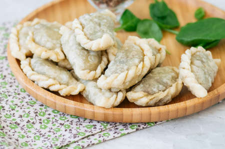 Fried savory pasties - hand pies with spinach on a white background. Top view and copy space.の写真素材
