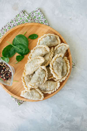 Fried savory pasties - hand pies with spinach on a white background. Top view and copy space.の写真素材
