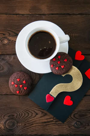 A cup of black coffee and chocolate cookies on a wooden backdrop. Valentine's Day background. の写真素材