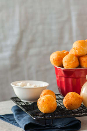Small cottage cheese doughnuts (castgnole) served on a wire rack. White stone background.の写真素材