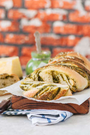 Slices of pesto braided bread on napkin, white stone background. Still life.の写真素材