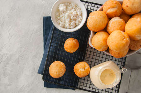 Small cottage cheese doughnuts (castgnole) served on a wire rack. White stone background.の写真素材
