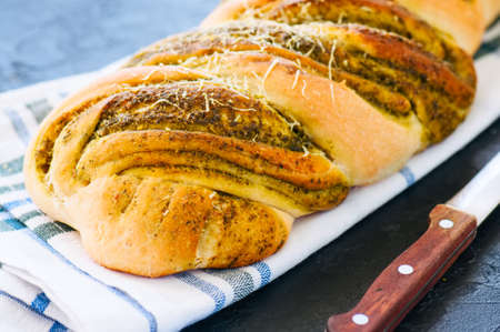 Pesto braided bread on napkin, black stone backgroundの写真素材