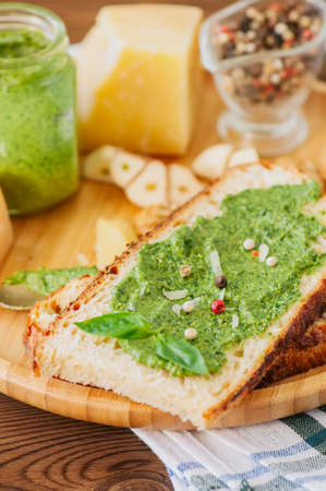 Bruschetta with basil walnut pesto sauce on a wooden plate. Wooden backdrop.の写真素材