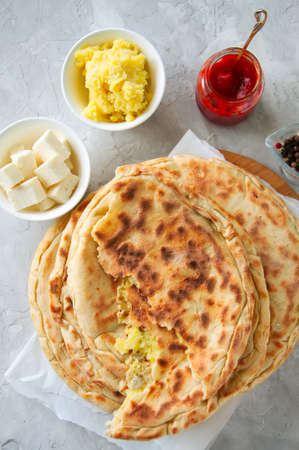 Mashed potato and sheep cheese filling flatbread on a white stone background.の写真素材