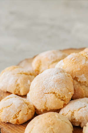 Homemade amaretti cookies on a wooden board on a white stone backdrop.の写真素材