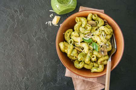 Pasta with basil pesto and herbs in a plate on a stone background.の写真素材