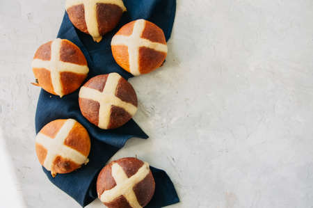 Chocolate and classic hot cross buns on a white stone background. Copy space.の写真素材