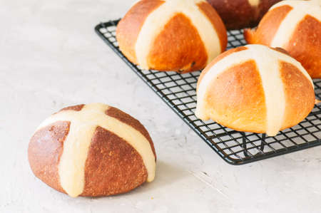Chocolate and classic hot cross buns on a white stone background. Copy space.の写真素材