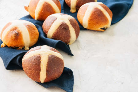 Chocolate and classic hot cross buns on a white stone background. Copy space.