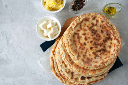 Mashed potato and sheep cheese filling flatbread on a white stone background.の写真素材