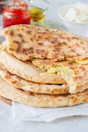 Mashed potato and sheep cheese filling flatbread on a white stone background.の写真素材