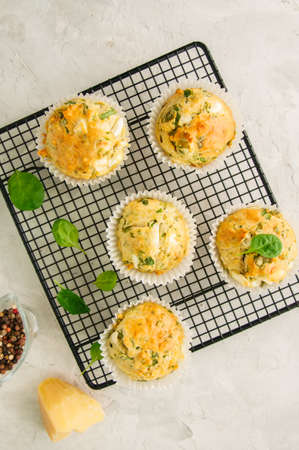 Savory muffins with feta cheese and spinach on a wire rack on a wire rack.White stone backdrop. の写真素材