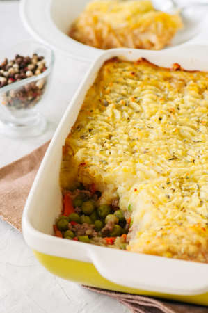 Shepherds pie -  Irish traditional food. Served in a ceramic dish on a white stone background.の写真素材
