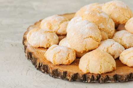 Homemade amaretti cookies on a wooden board on a white stone backdrop.の写真素材