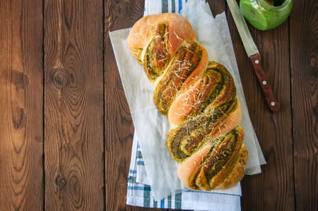 Italian pesto braided bread on a napkin, wooden background. Top view.の写真素材