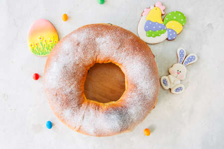 Reindling - Austrian or German festive yeasty baking for Easter. Ring cake served on a wooden plate on a white stone background.の写真素材