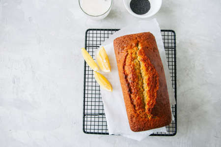 Homemade lemon poppy seed pound cake on a wire rack. White stone background.の写真素材