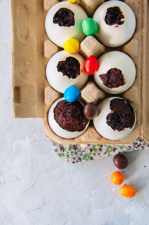 Dark chocolate brownie dessert in egg shells. Easter or funny kids party concept. White stone background.  の写真素材