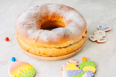 Reindling - Austrian or German festive yeasty baking for Easter. Ring cake served on a wooden plate on a white stone background.の写真素材
