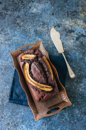 Chocolate banana date dread on a vintage tray on a blue stone background. Copy space.の写真素材