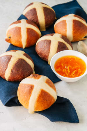 Homemade chocolate and classic hot cross buns with raisins on a white stone background. Copy space.の写真素材