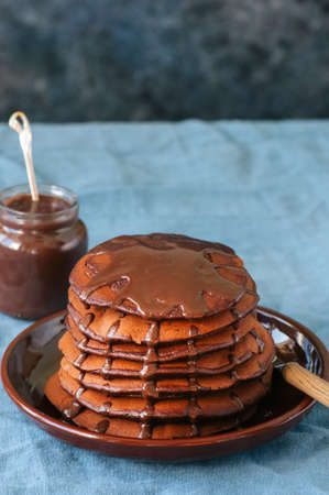 Chocolate pancakes wiyh syrup in a plate on a blue background.の写真素材