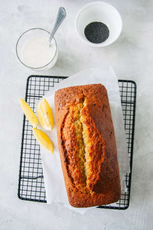 Homemade lemon poppy seed pound cake on a wire rack. White stone background. Top view.の写真素材