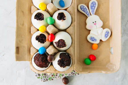 Dark chocolate brownies in egg shells. Easter or funny kids party concept. White stone background.の写真素材