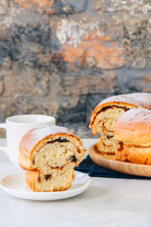 Reindling - Austrian or German festive yeasty baking for Easter. Ring cake served on a wooden plate on a white stone background.の写真素材