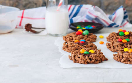 Chocolate bird's nest cookies decorated with colorful candies on a white background. の写真素材