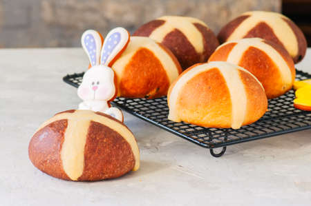 Homemade chocolate and classic hot cross buns with raisins on a white stone background. の写真素材