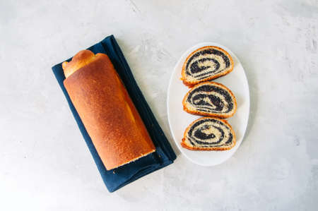 Traditional polish festive pastry - Makowiec- Poppy seed roll on a  white stone background.の写真素材
