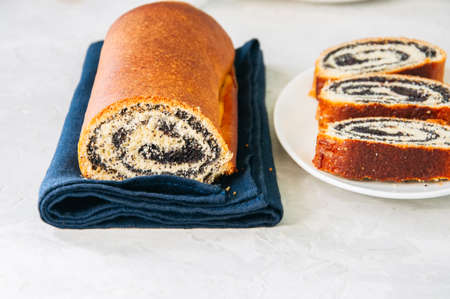 Traditional polish festive pastry - Makowiec- Poppy seed roll on a  white stone background.の写真素材