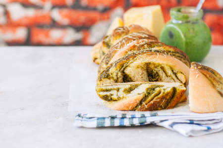 Pesto braided bread on a napkin, White stone background. Copy space.の写真素材
