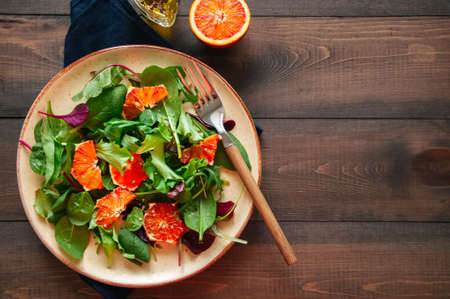 Fresh salad mix with blood oranges on a wooden background.  Top view. Healthy eating concept. の写真素材