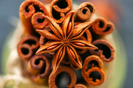Close up of anise star and bundle of cinnamon sticks.