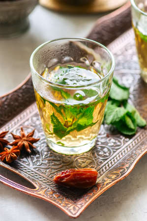 Traditional moroccan mint tea with dates on a vintage tray. White stone background.の写真素材