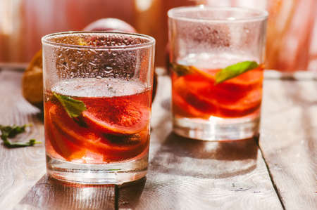 Refreshing blood orange water or infused water in a glass on a wooden background.の写真素材